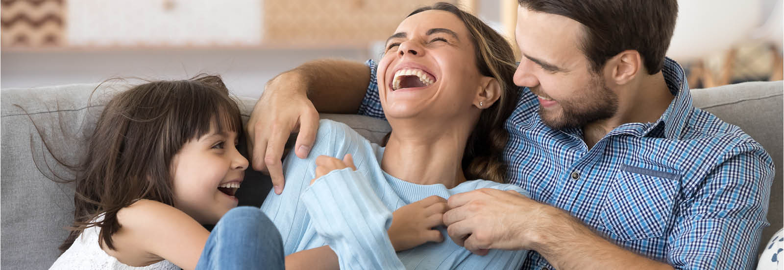 family of three laughing and smiling 1600X552.jpg