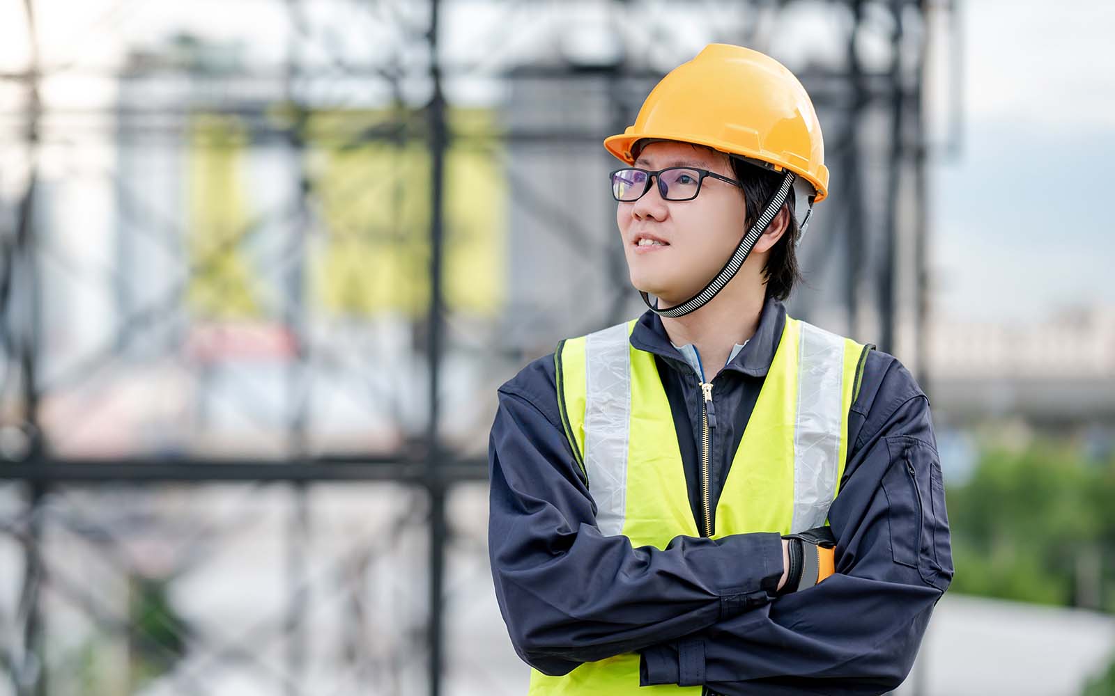 Asian maintenance worker man wearing reflective suit and safety helmet working at construction site. Civil engineering, Architecture builder and building service concepts