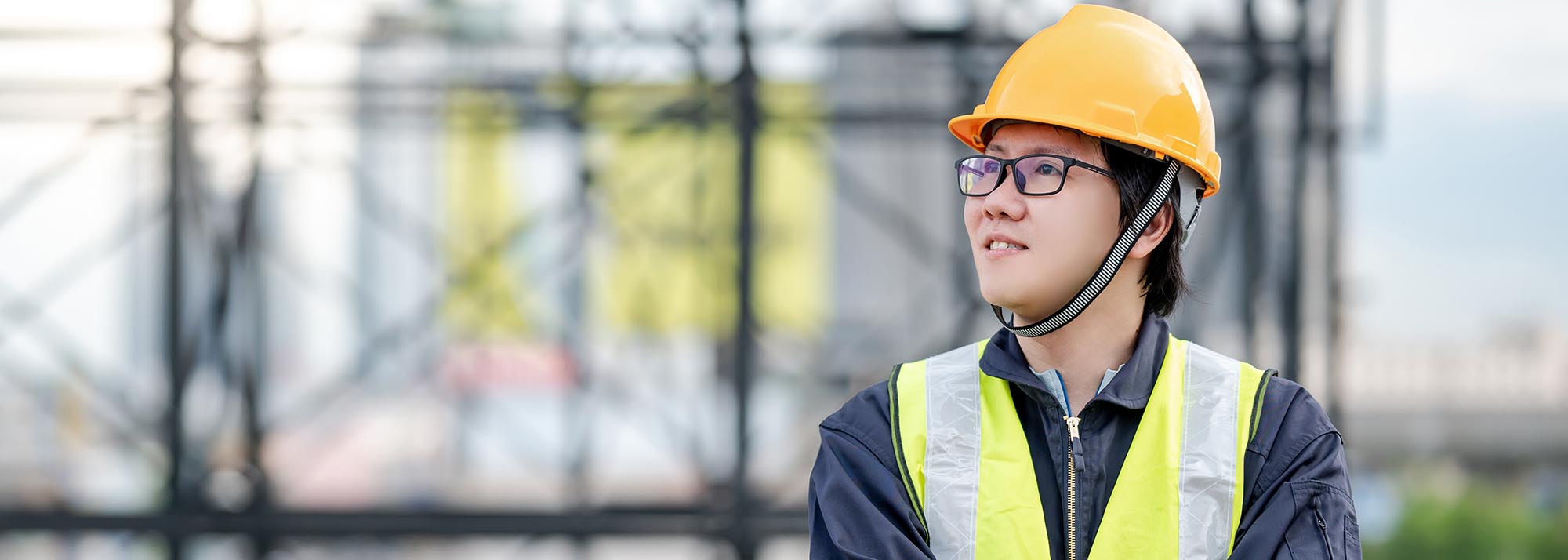 Asian maintenance worker man wearing reflective suit and safety helmet working at construction site. Civil engineering, Architecture builder and building service concepts