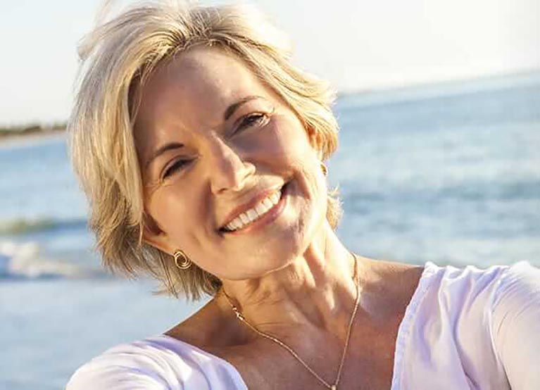 older woman smiling on the beach-mobile.jpg