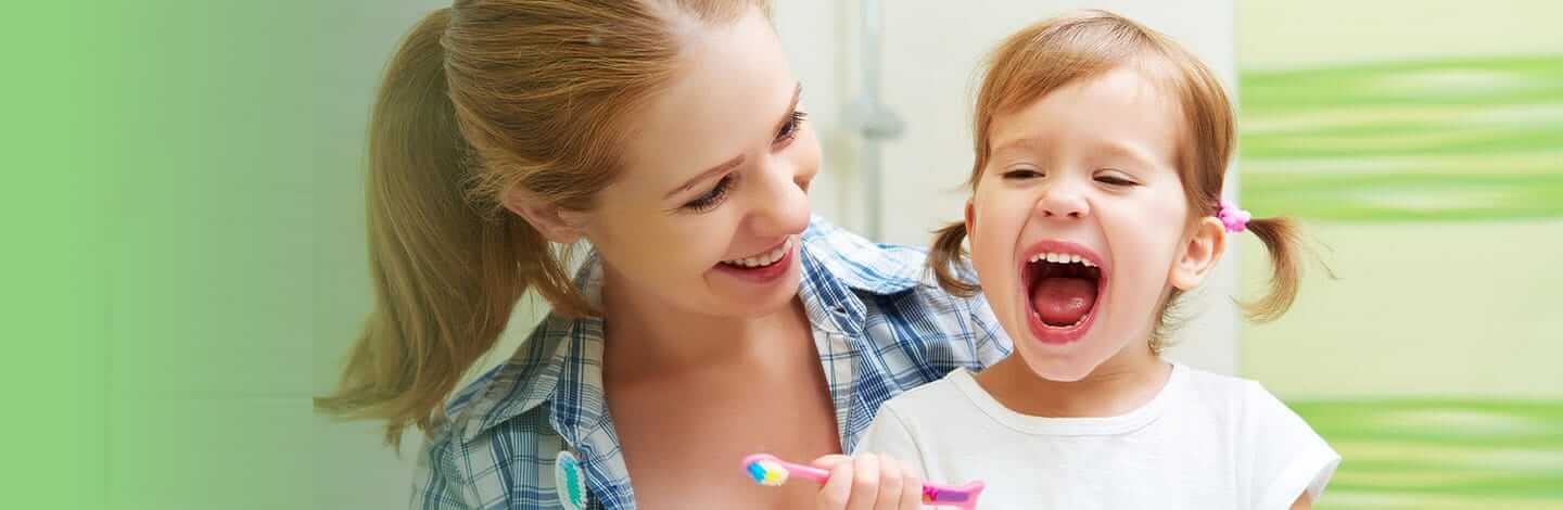 mother helping daughter brush teeth.jpg