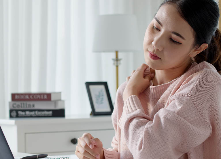 young asian woman rubbing shoulder from stress at work mobile 767x554.jpg